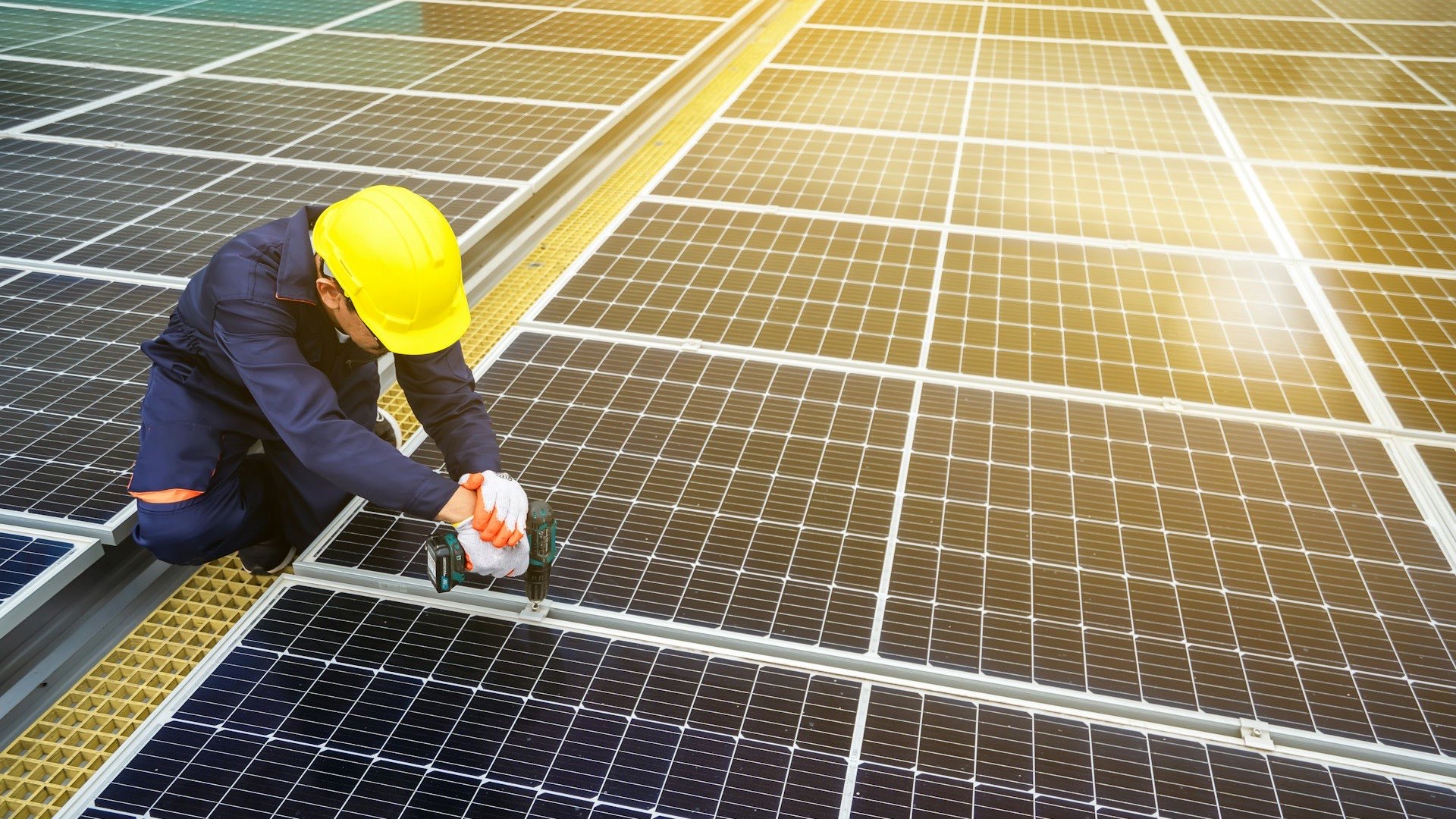 Técnico con casco instalando paneles solares